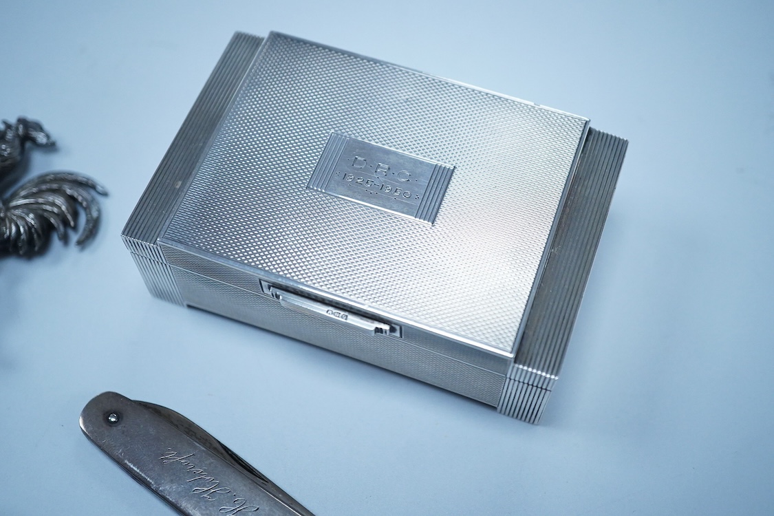 A George VI Art Deco engine turned silver mounted trinket box, by Dudley Russell Howitt, Birmingham, 1947, width 85mm, together with a late Victorian silver fruit knife, a silver thimble, a white metal cockerel mounted s
